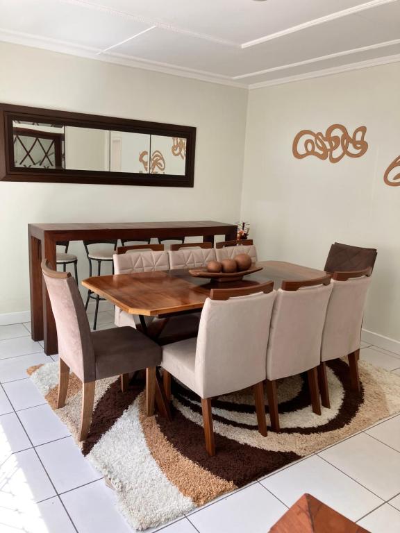 uma sala de jantar com uma mesa de madeira e cadeiras em Duplex do Largo em Curitiba