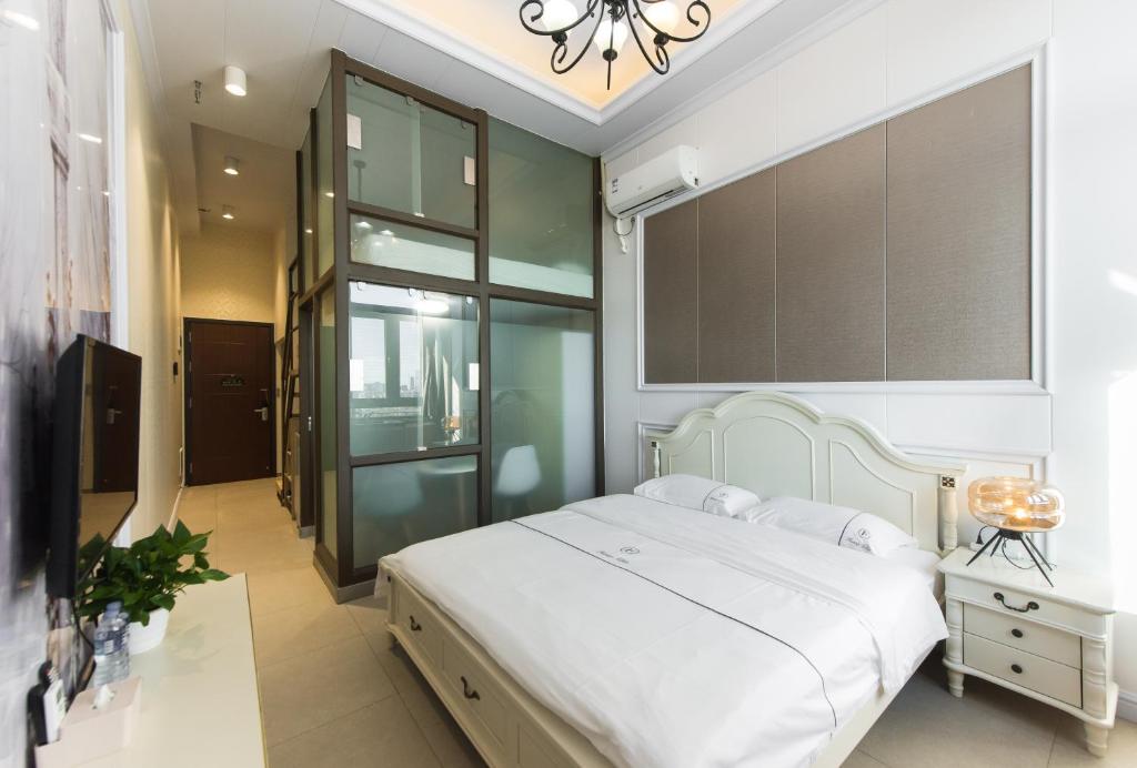 Postel nebo postele na pokoji v ubytování WESU Weisu Executive Apartment Shenzhen Shenda Metro Store