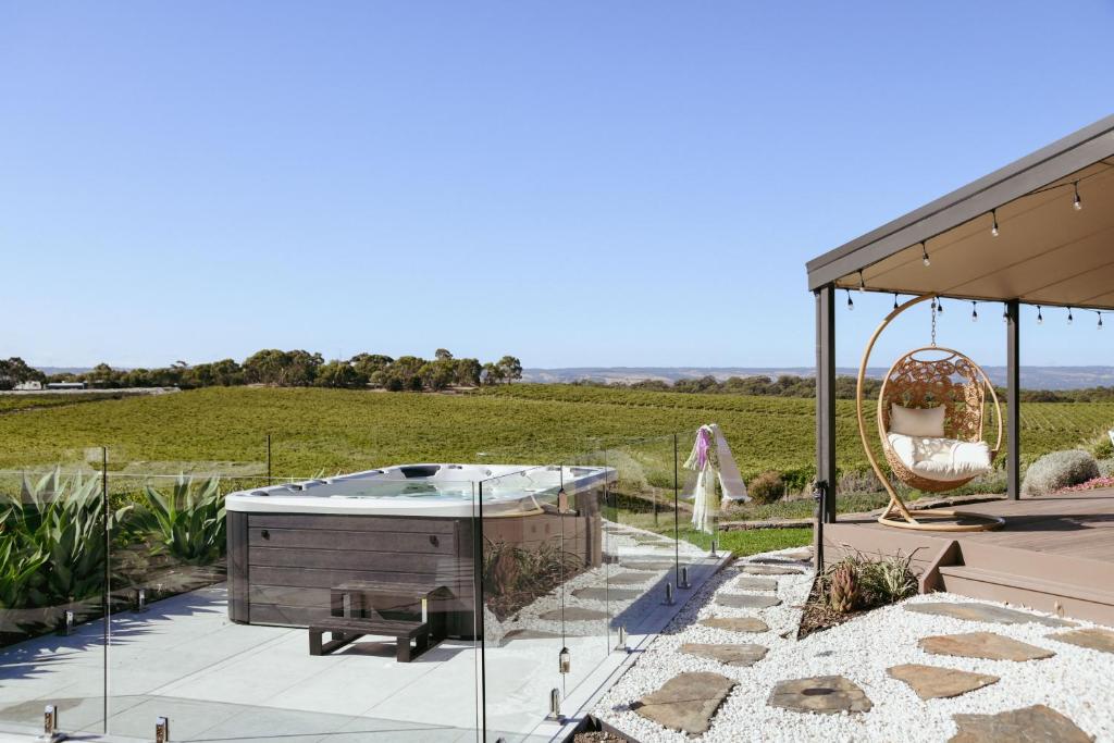 un patio con bañera de hidromasaje y columpio en Miravino – breathtaking vineyard views en McLaren Vale