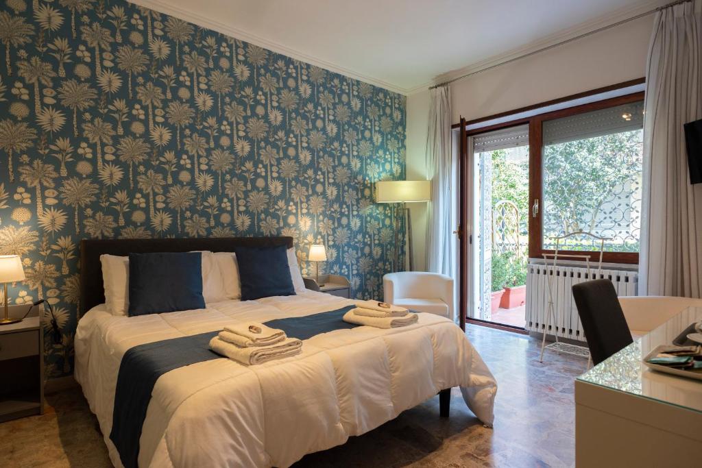 a bedroom with a bed with a blue and gray wallpaper at Room 66 in Naples