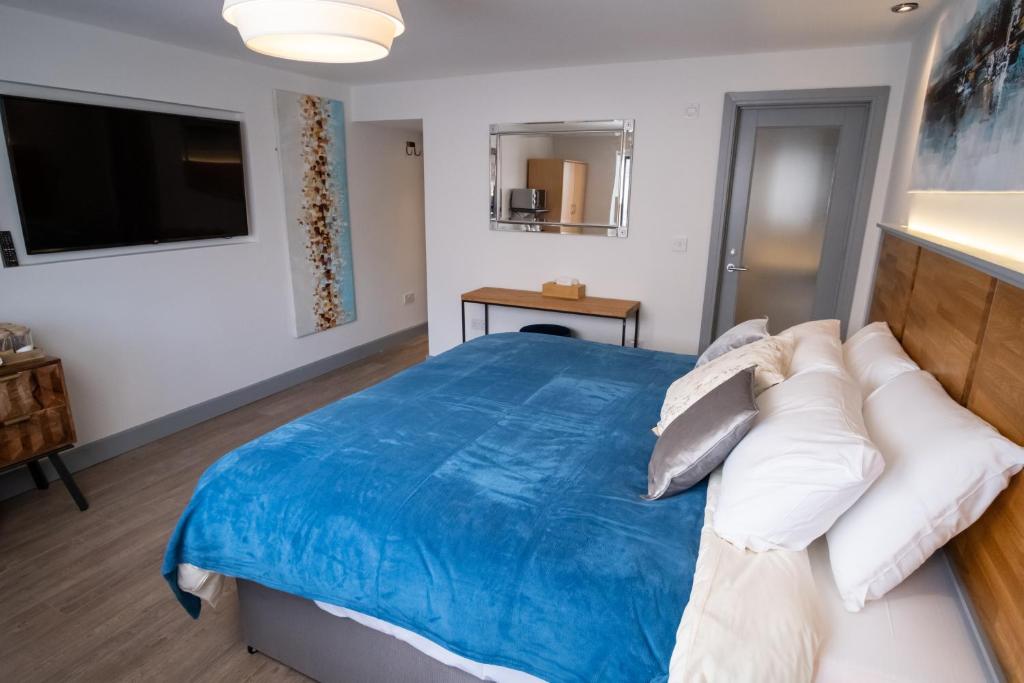 a bedroom with a blue bed and a television at Magnolia House, Rye in Rye