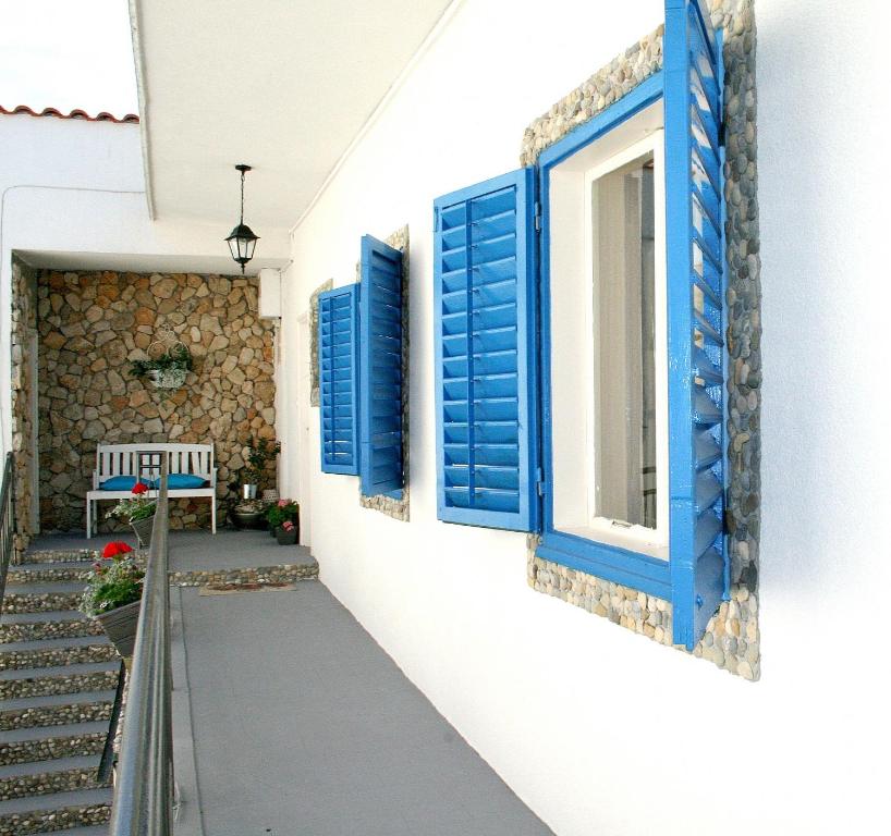 a house with blue shuttered windows and a bench at Apartment Tina in Vodice