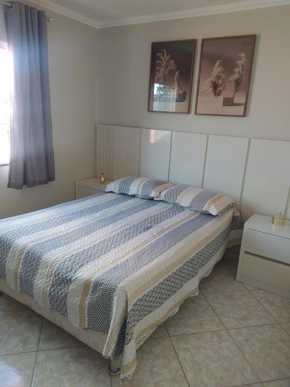 Un dormitorio con una cama grande con dos almohadas. en imóvel ideal para suas férias em Canto Grande, en Bombinhas