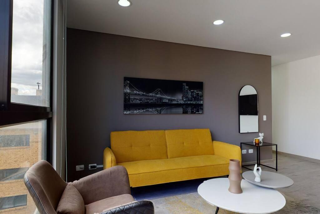 sala de estar con sofá amarillo y mesa en Apartamento 601 kappadoccia, en Bogotá