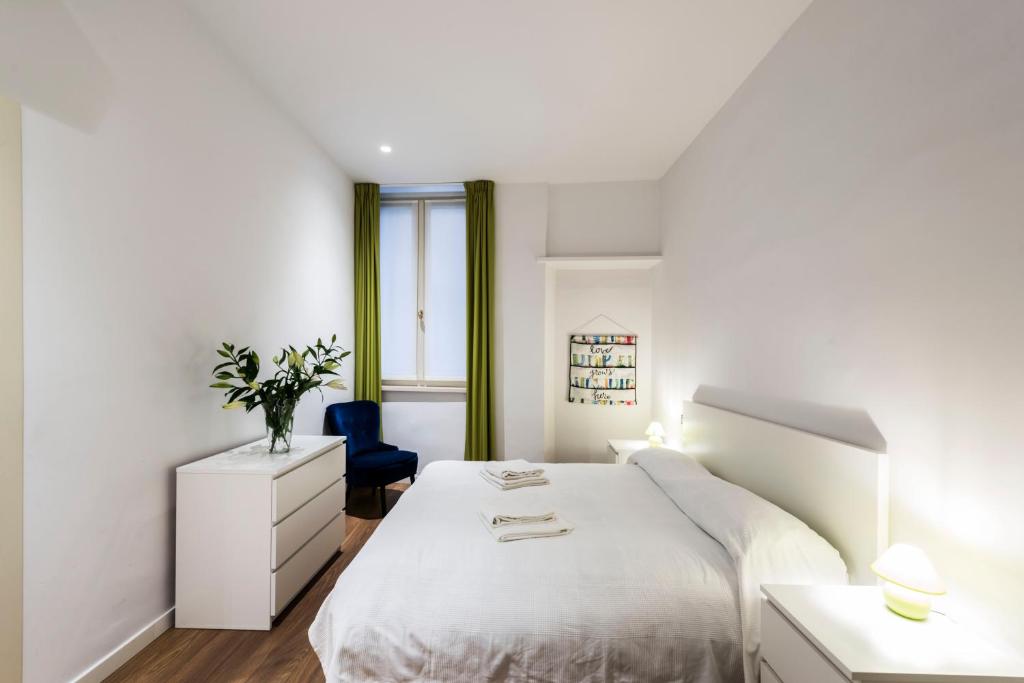 ヴェローナにあるAppartamento Via Valverde 4の白いベッドルーム(白いベッド1台、青い椅子付)