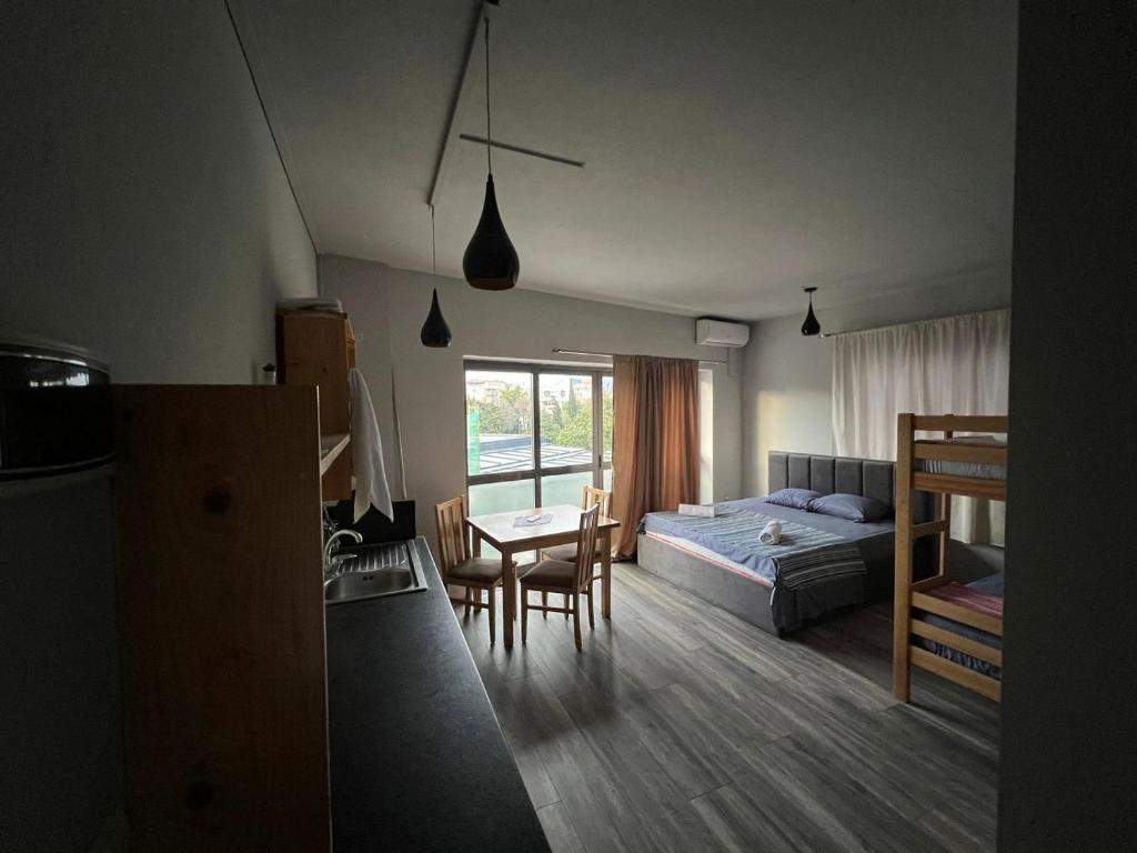 um quarto com uma cama, uma mesa e cadeiras em The Rooftop Hostel em Shkodër