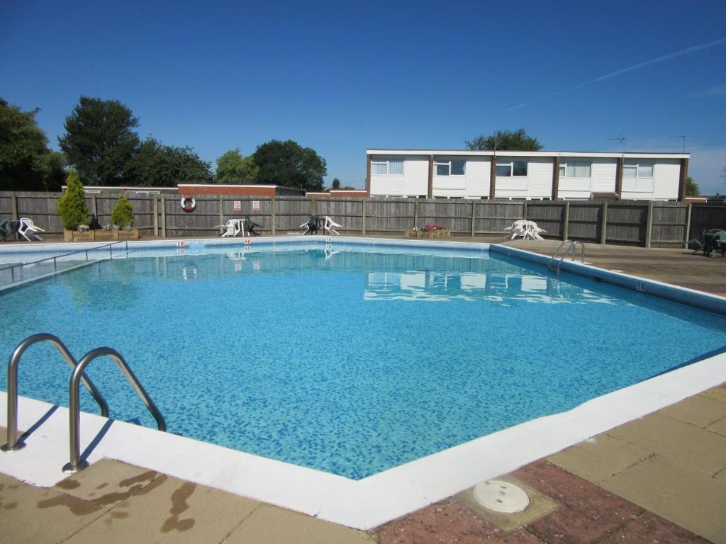 een groot zwembad met blauw water bij 2 Storey 3 Bedroom Chalet -Outdoor Swimming Pool - sleeps up to 6 - 5 min walk to the Beach, near Broads and Great Yarmouth in Scratby