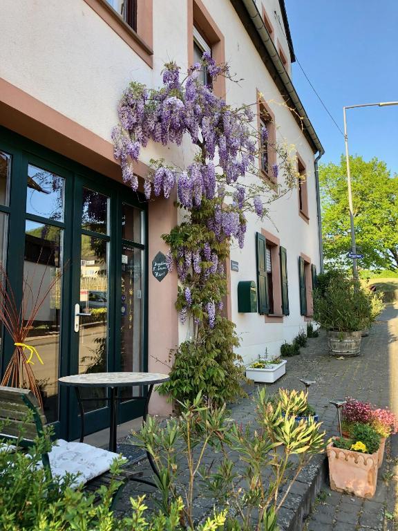 a building with a wreath of purple flowers on it at Ferienweingut Matthias Löwen in Detzem