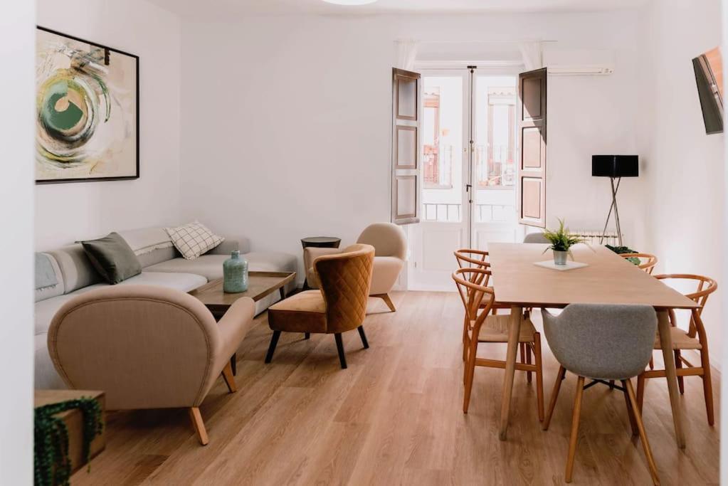 a living room with a couch and a table and chairs at Stylish apartment in the centre of Madrid-Malasaña in Madrid