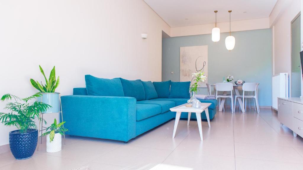 - un salon avec un canapé bleu et une table dans l'établissement Happiness Luxury Home, à Paleóchora