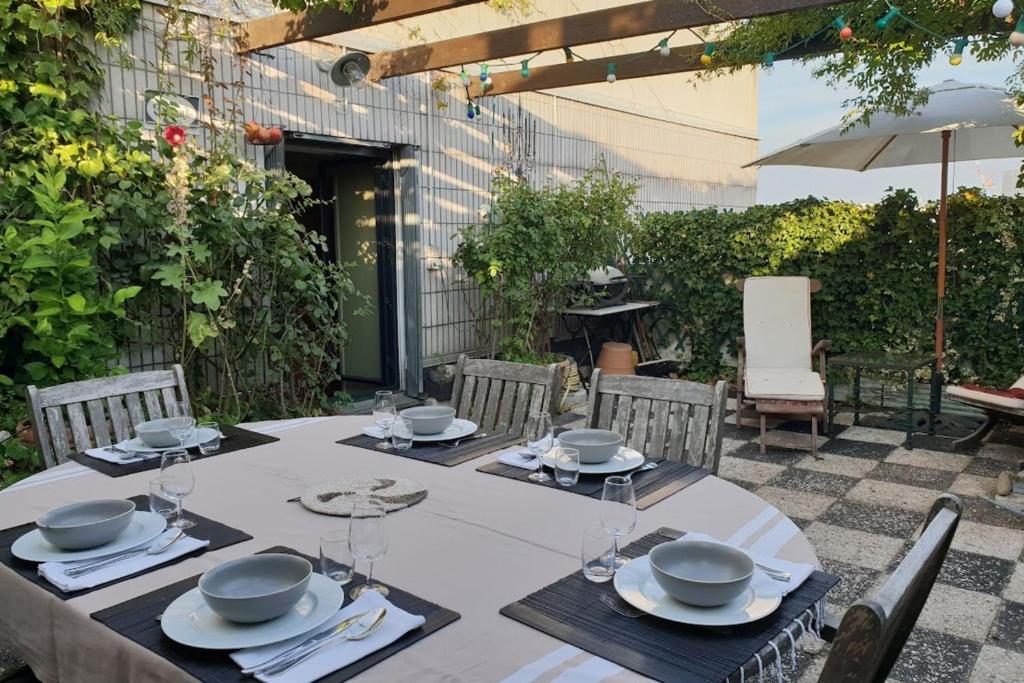 - une table avec des assiettes et des serviettes sur une terrasse dans l'établissement Apt quiet and bright with large terrace, à Paris