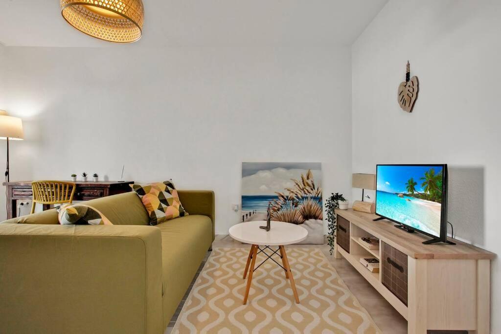 un soggiorno con divano e TV a schermo piatto di Casa Tornasol a Corralejo