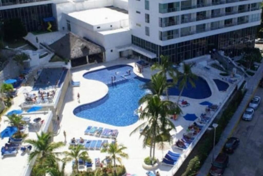 an overhead view of a pool with palm trees and a building at DEPARTAMENTO ACAPULCO EN ZONA DIAMANTE in Acapulco