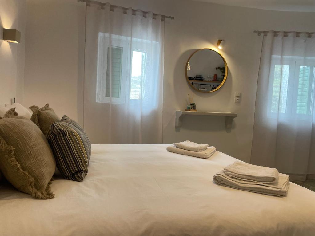 a bedroom with a large white bed with a mirror at Dryopis Studio in Dhriopís