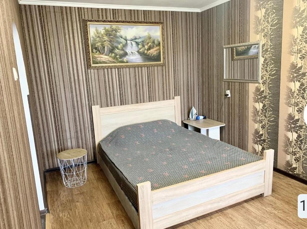 - une chambre avec un lit et une peinture murale dans l'établissement Апартаменты в самом Центре прПобеды 90, à Tchernihiv