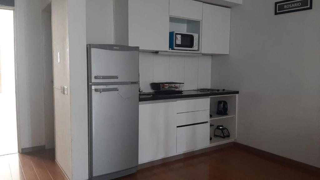 a white kitchen with a refrigerator and a microwave at BERSAGLIERE in Rosario