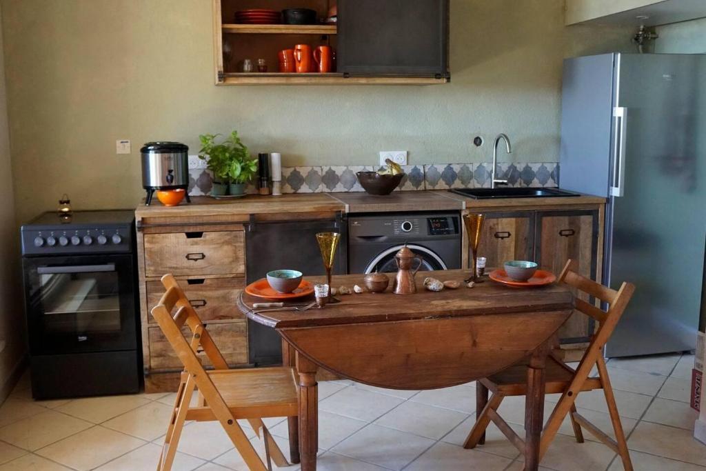 a kitchen with a table and chairs and a refrigerator at Beachside Apartment - Sleeps 2 in Cerbère