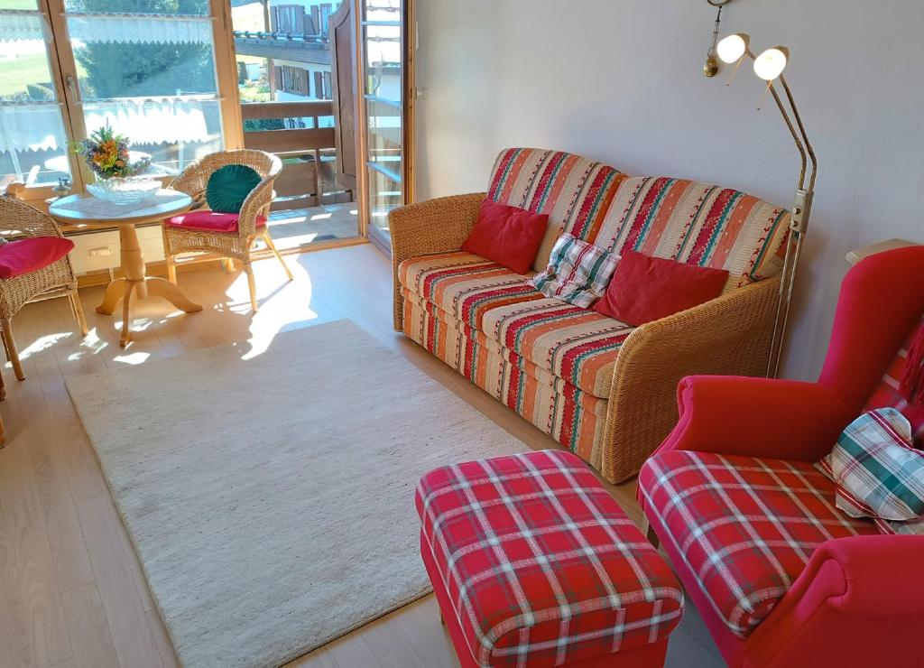 ein Wohnzimmer mit einem Sofa und einem Tisch in der Unterkunft Falkenhorst in Fischen im Allgäu