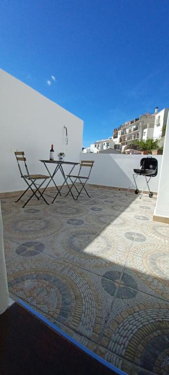 un patio avec deux chaises et une table sur un bâtiment dans l'établissement Castra Vinaria, à Casarabonela