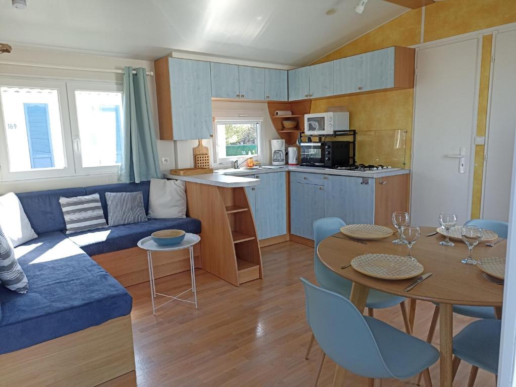 - un salon avec un canapé bleu et une table dans l'établissement LA CASA, à Biville-sur-Mer