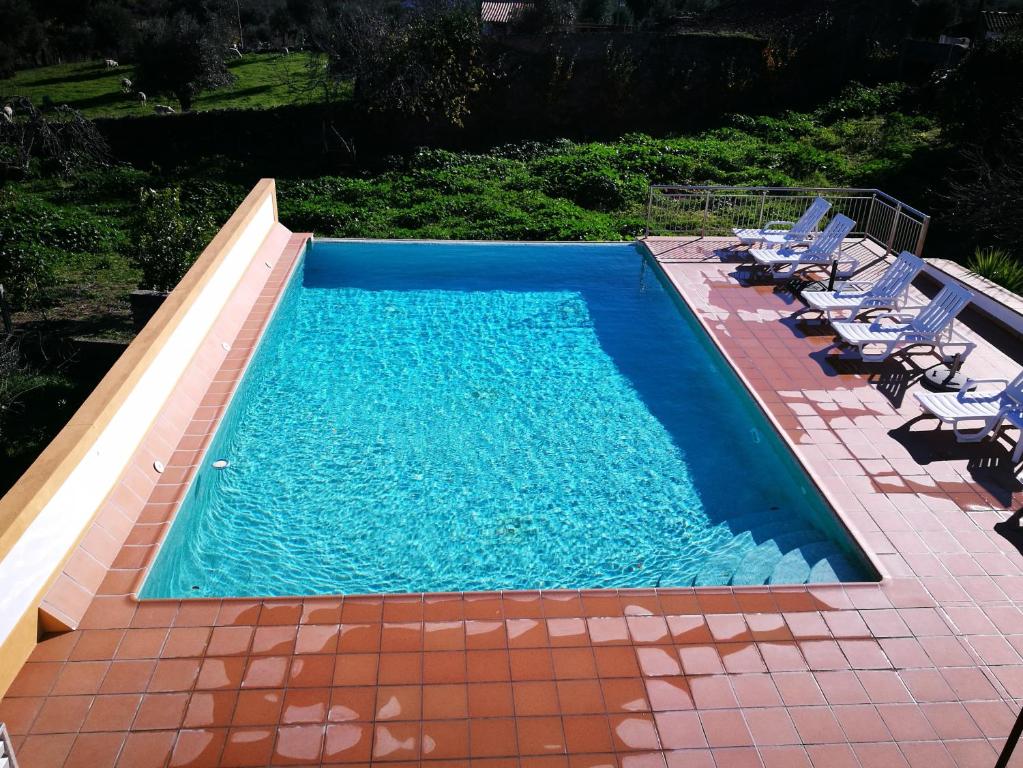 a swimming pool with chairs and a swimming poolvisor at Casa do Peso in Crato