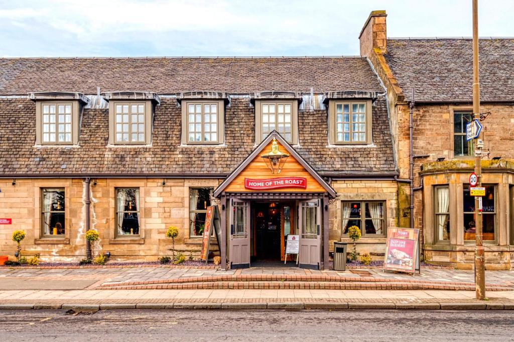 een oud bakstenen gebouw op de hoek van een straat bij Toby Carvery Edinburgh West by Innkeeper's Collection in Edinburgh