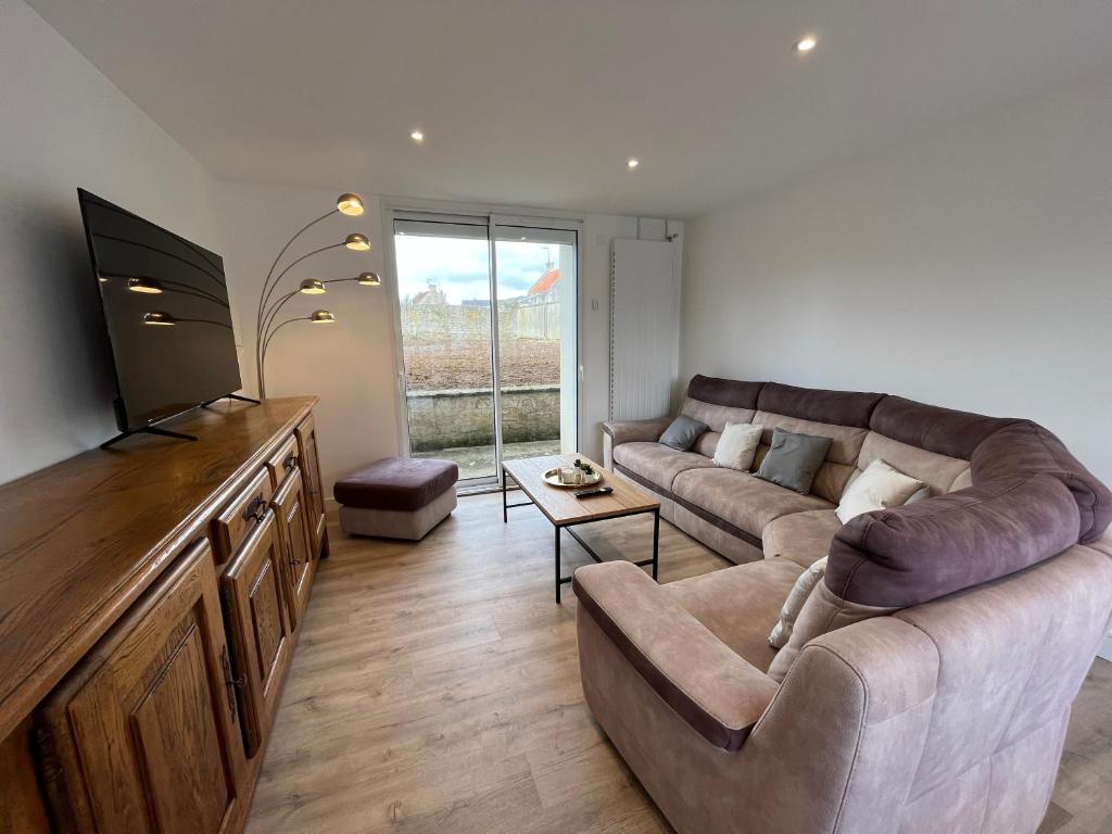 un salon avec un canapé et une télévision à écran plat dans l'établissement Etanin, Maison entièrement rénové proche mer et ville, à Bény-sur-Mer