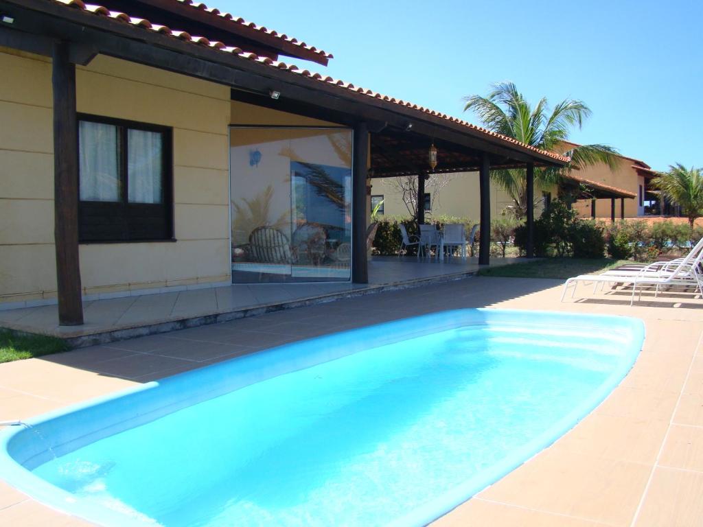 ein Pool vor einem Haus in der Unterkunft Casa espetacular em condomínio pé-na-areia, PZ11 in Rio do Fogo