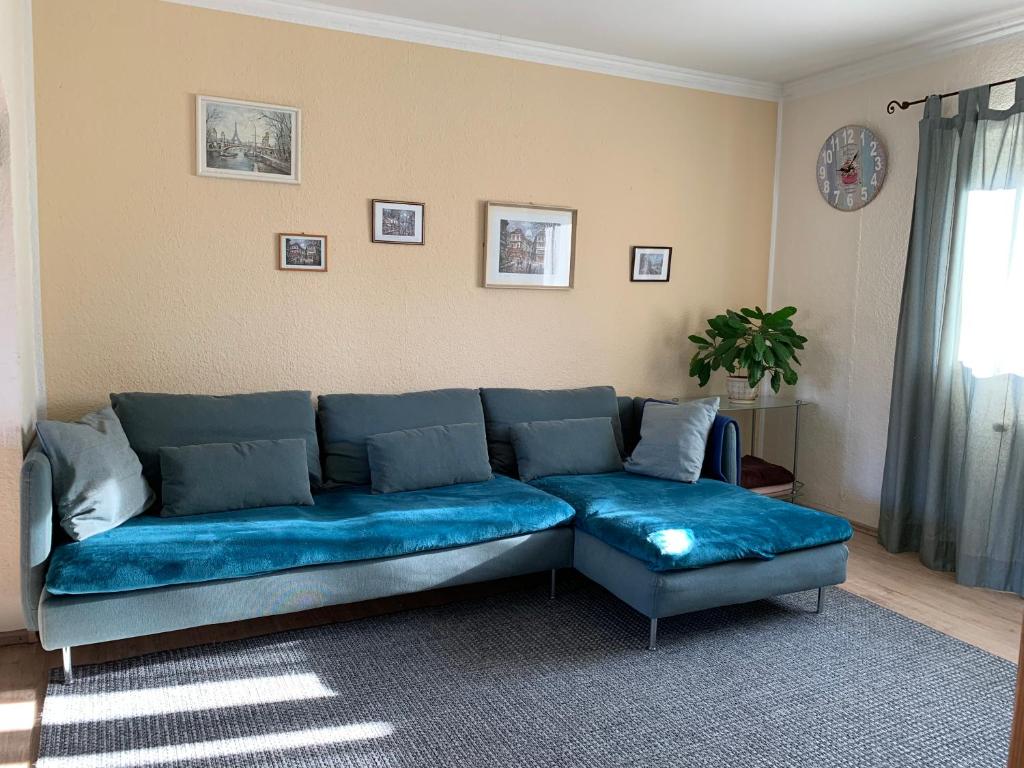 eine blaue Couch im Wohnzimmer in der Unterkunft Ferienwohnung mit Garten in Köln in Köln