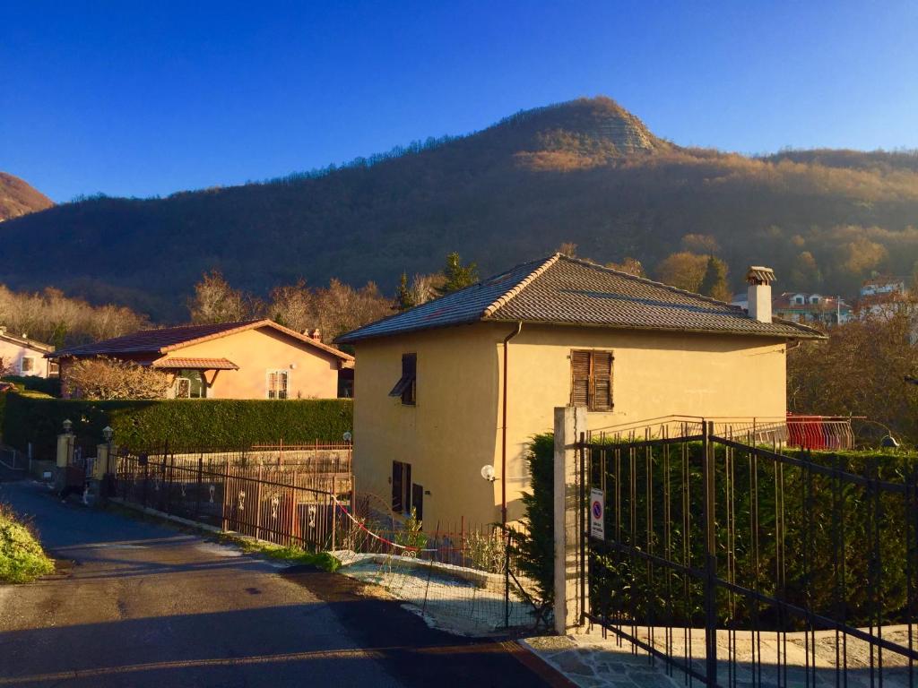 a house with a fence in front of a mountain at L'Angolo Divino in Casella
