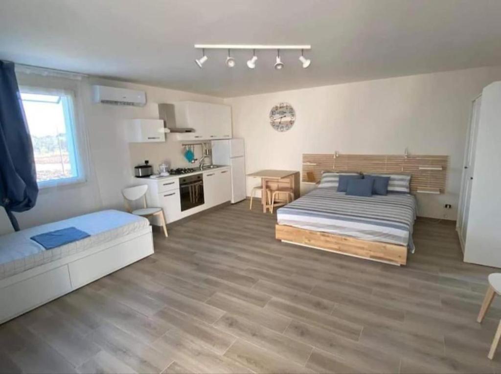Cet appartement comprend une chambre avec un lit et une table ainsi qu'une cuisine. dans l'établissement Loft Salento Sweet Life - con terrazza esclusiva, à Vignacastrisi