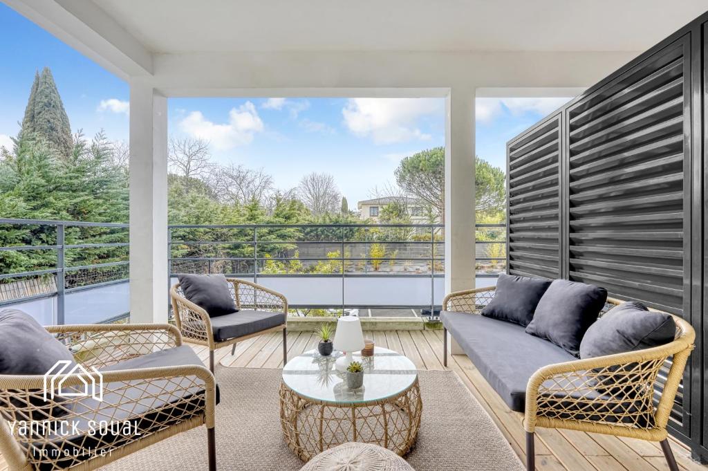 een woonkamer met een bank en stoelen op een balkon bij L'ORMEAU FLAMINGO in Toulouse