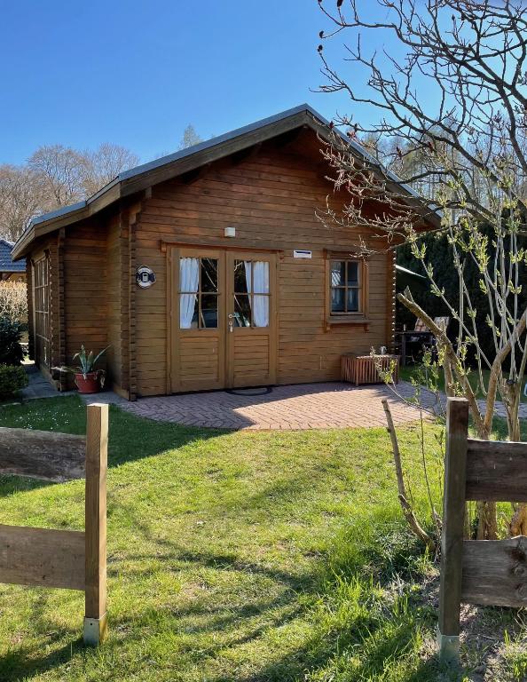 a log cabin with a large yard in front of it at TinyHouse Meereszauber- ruhige Lage, eigener Garten, Grill in Wolgast