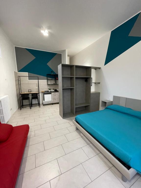 Un dormitorio con una cama azul y una mesa en MONOLOCALE PIAZZA FONTANA GRANDE ALLOGGIO TURISTICO, en Viterbo