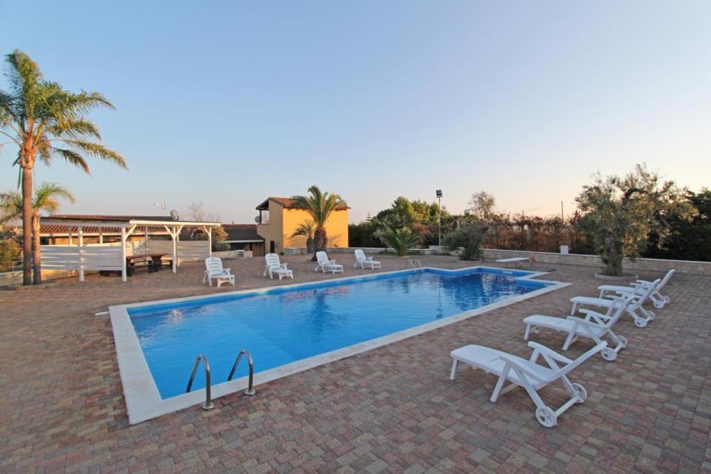 a swimming pool with lounge chairs and a swimming pool at Villa Rita in Racale