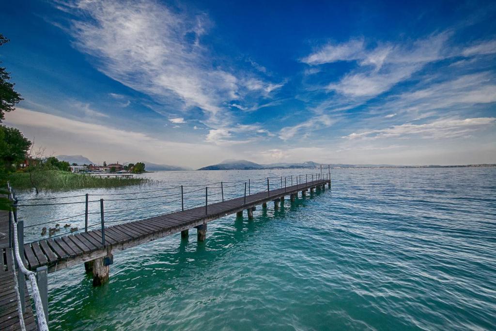 a dock in the middle of a large body of water at Hotel Aurora in Sirmione