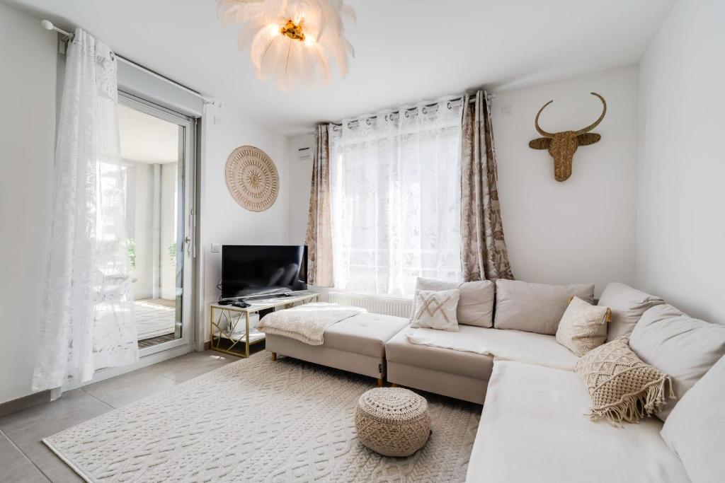 a living room with a white couch and a tv at Le Bohème - Charming apartment in the city centre in Annecy