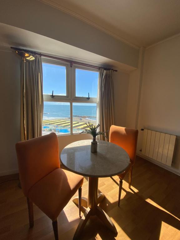 uma sala de jantar com uma mesa e cadeiras e uma janela em Hotel Atlántico Suites em Mar del Plata