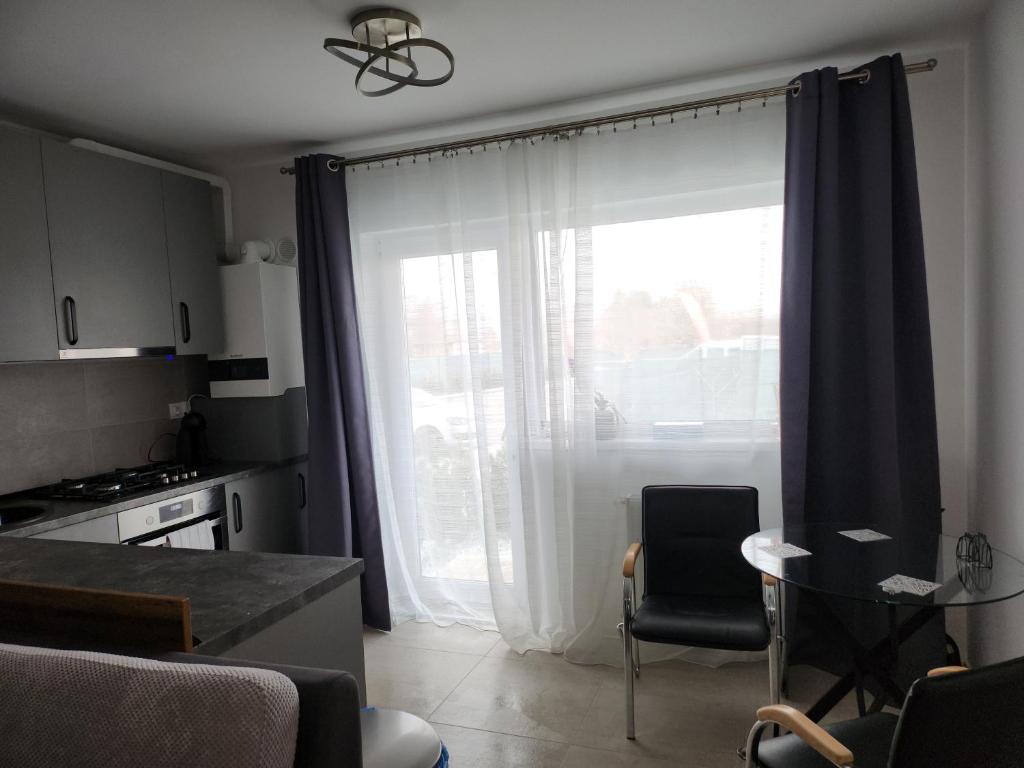 a kitchen with a large window with a table and chairs at Coder Studio in Braşov