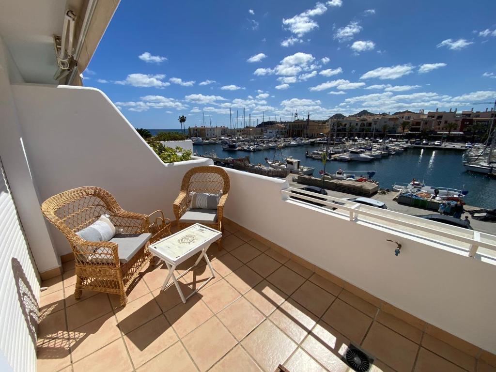 a balcony with chairs and a view of a marina at LA CASA DEL PUERTO DE CABO DE PALOS - GARAJE INCLUIDO in Cabo de Palos