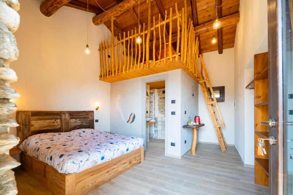 1 dormitorio con 1 cama y escalera de madera en Country House Le Gaie Allegre, en Villar San Costanzo