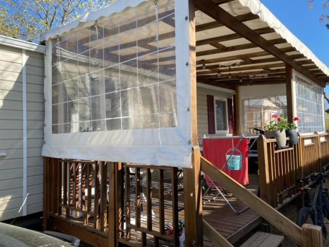 una veranda schermata con tenda da sole su una casa di MOBIL HOME LE STEPHANOIS VALRAS a Valras-Plage