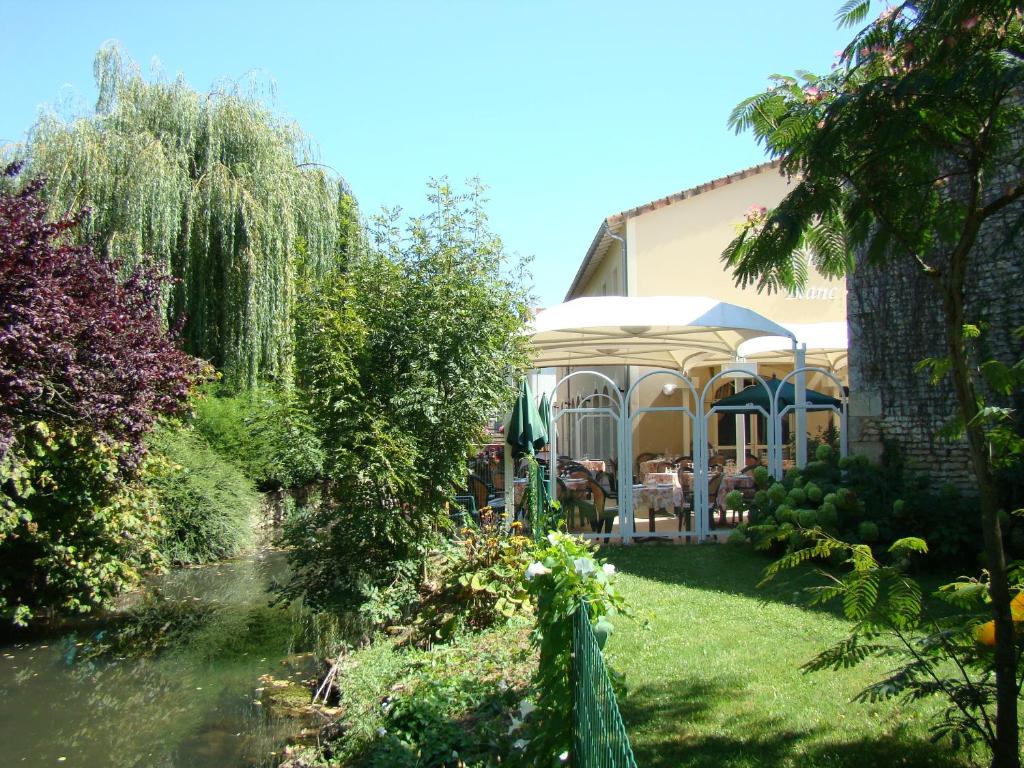 a house with a gazebo in a garden at Logis Le Cheval Blanc et Le Clovis in Vouillé
