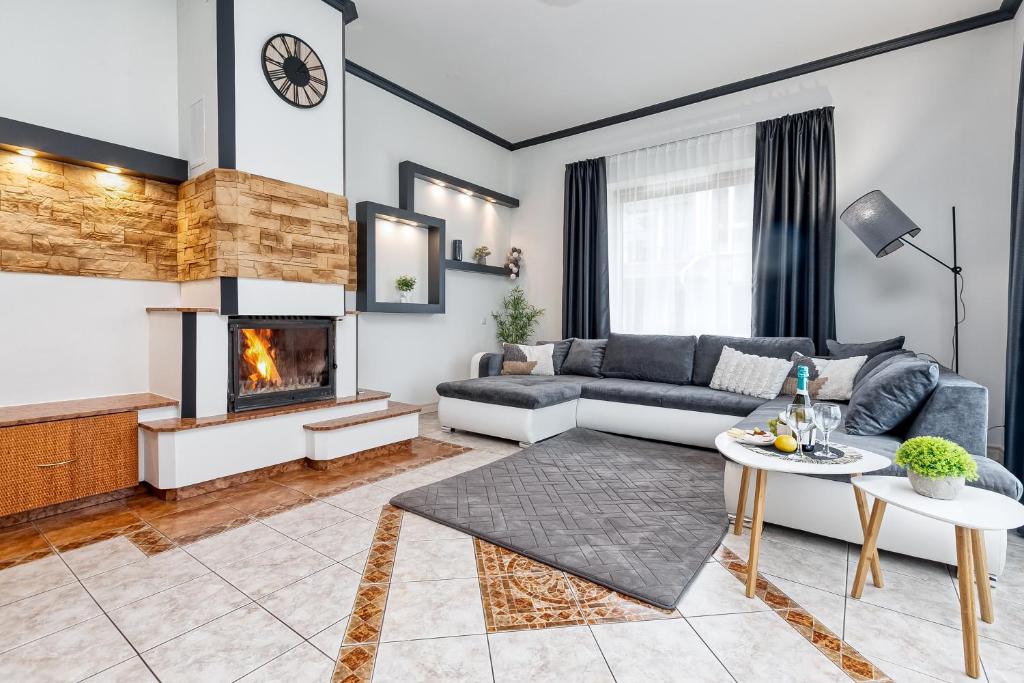 a living room with a couch and a fireplace at Jekaba Rezidence in Jelgava
