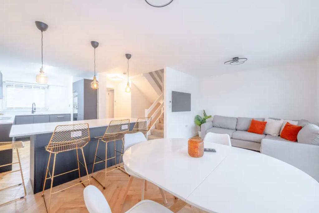 een keuken en een woonkamer met een witte tafel en stoelen bij Central 3BD Flat with Balcony in Paddington in Londen