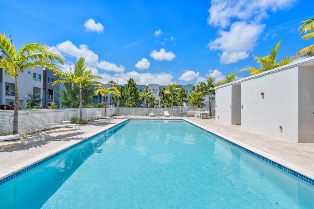 a swimming pool with palm trees and a building at Lofts of Aventura in Miami