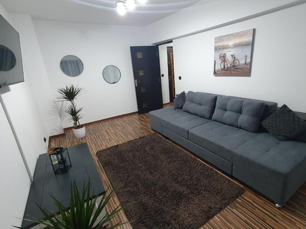 een woonkamer met een bank en een tafel bij Apartament EXCLUSIVE Târgu Ocna in Tîrgu Ocna