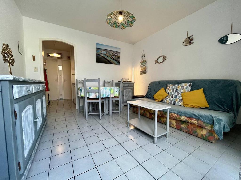 ein Wohnzimmer mit einem Sofa und einem Tisch in der Unterkunft Appartement Saint-Georges-d'Oléron, 2 pièces, 3 personnes - FR-1-246A-189 in Saint-Georges-dʼOléron
