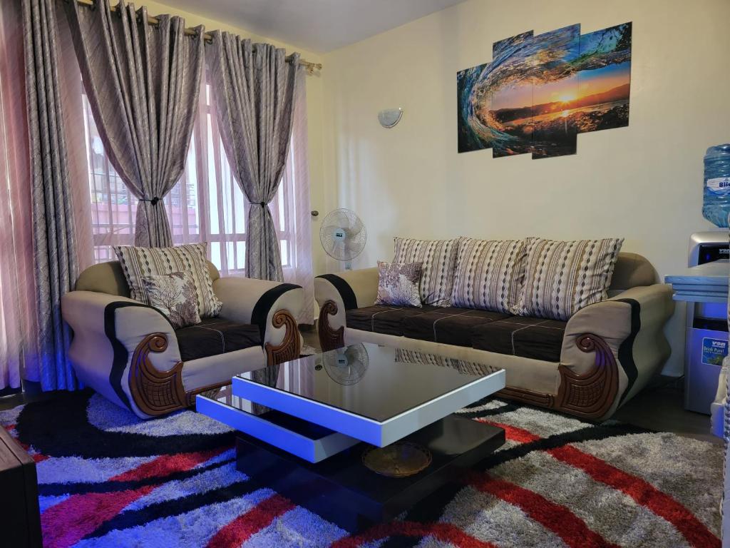 un soggiorno con divano e tavolino da caffè di Sweet Homes Apartment Near all Embassies a Ruaka