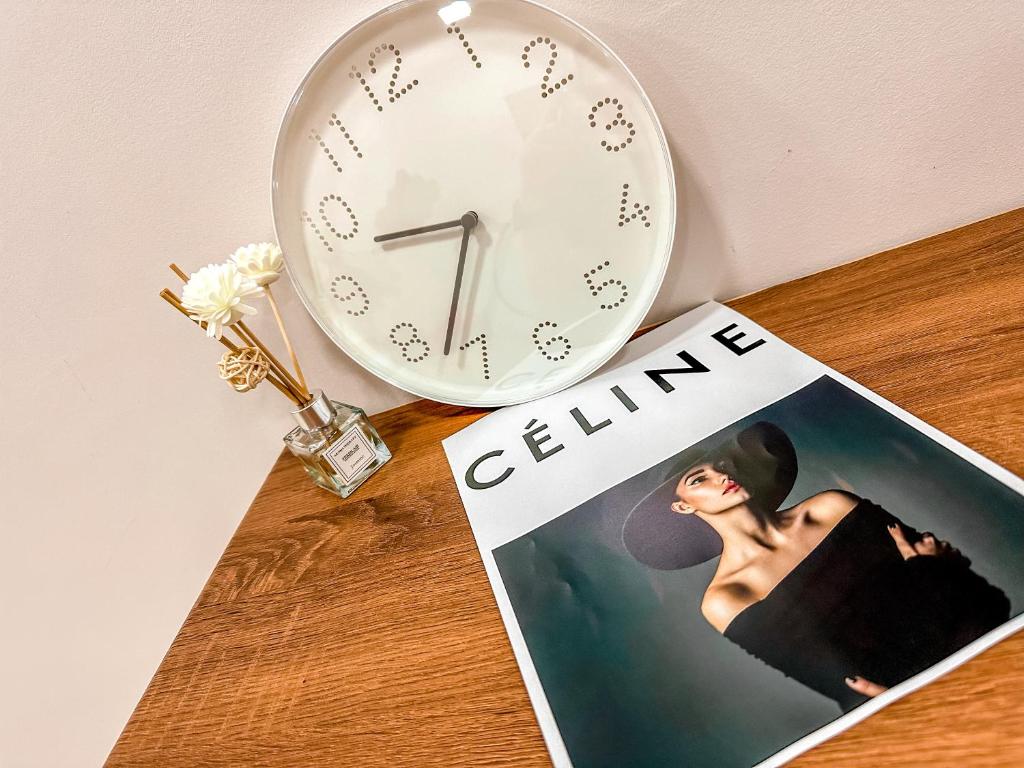 a clock sitting on a table next to a magazine at [Starry Homes x Classic] 2Beds+2Bath *Free Netflix in Masai